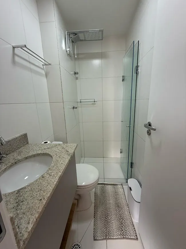 Banheiro do Studio Mobilité Righeto com box de vidro e planejados