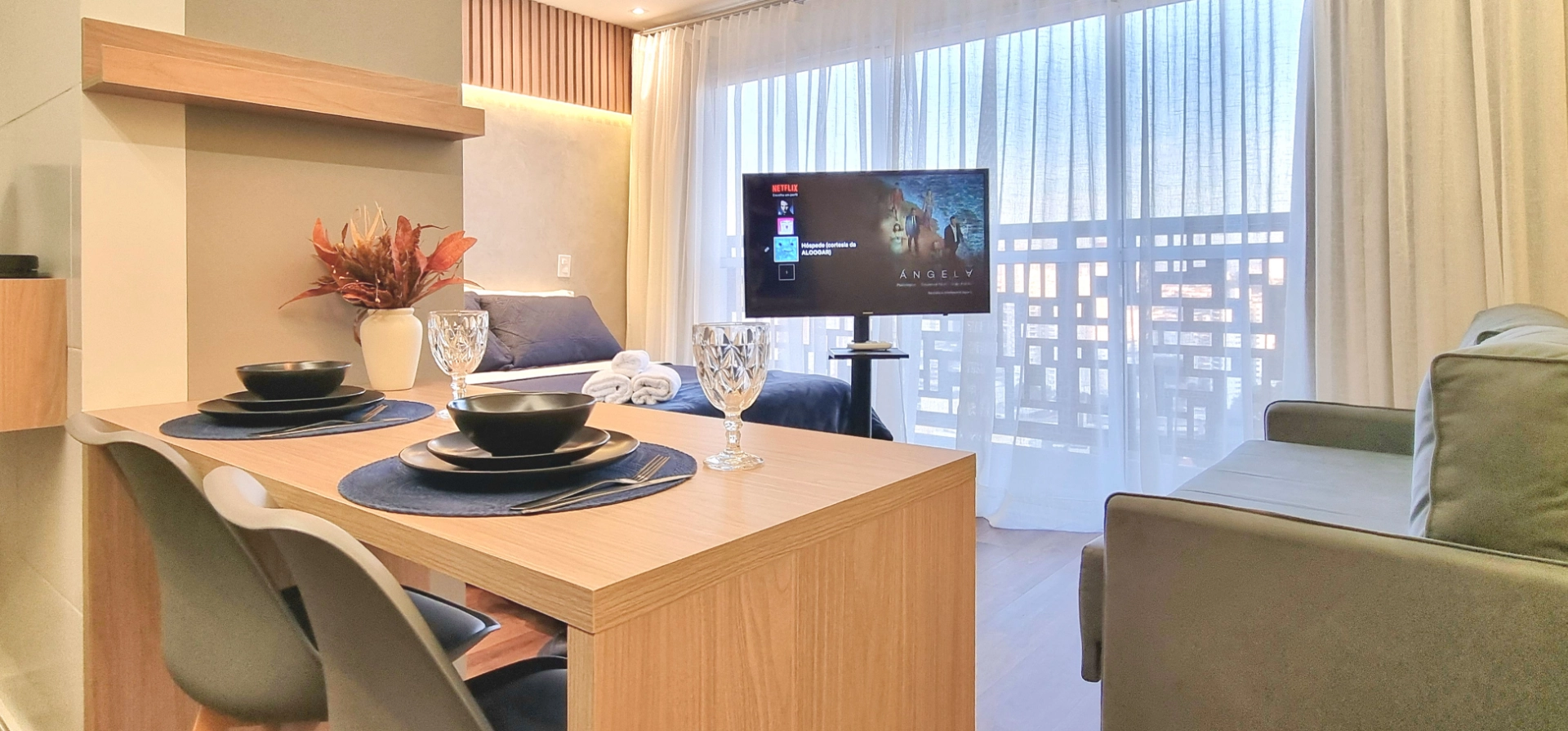 Studio Mobilité Righeto — sala integrada com parede amarela e vista da cidade